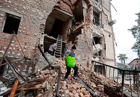 Venäjän pommituksessa tuhoutuneen talon asukkaat kantoivat tavaroitaan pois kotinsa raunioista Kiovassa. Venäläisjoukot ovat kohdistaneet iskuja useisiin siviilikohteisiin. 