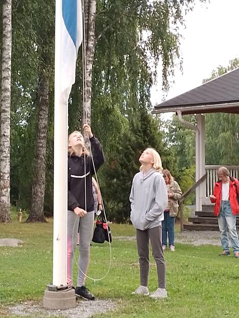 Henna ja Katriina Heikkilä nostivat lipun yhteisen leiripäivän aloituksessa.