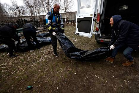 Vapaaehtoiset purkivat Butšassa maanantaina pakettiautoa, jonka kuormana oli ruumispusseja.