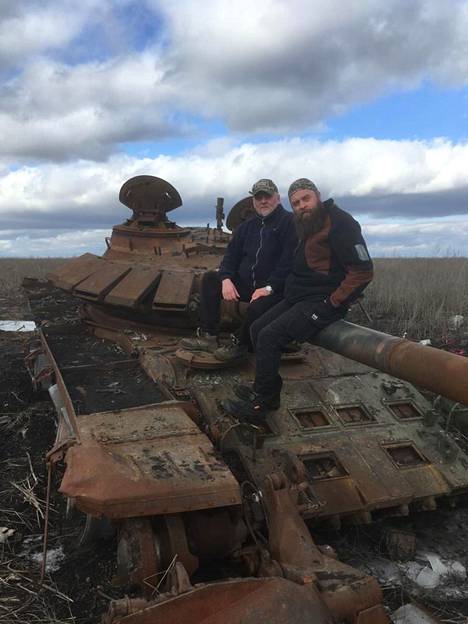 Pekka Itkonen (vas.) ja Mika Eerola taistelutantereelle tuhoutuneen panssarivaunun päällä. Kaksikko teki avustusmatkan Ukrainaan ja kertoo nyt kokemuksistaan.