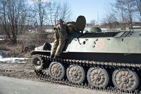 Ukrainalainen sotilas tutki tien varteen pysäytettyä venäläisten panssariajoneuvoa Kiovan lähistöllä Brovaryssa 10. maaliskuuta.