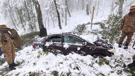 Lumimyrsky saartoi Murreen vuoristokaupungin Pakistanissa. Pelastustyöntekijät tutkivat lumeen hautautuneita autoja 8. joulukuuta.