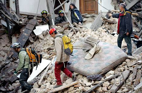 Pelastajat etsivät 6.4.2009 romahtaneen talon raunioista loukkuun jääneitä ihmisiä.