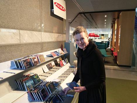 Tuija Nevala kokoaa levyjä hyllylle Tampere-talon pääaulassa sijaitsevassa uudessa myyntipisteessä.