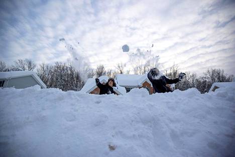 Lapsia lumentulo riemastuttaa. Lincoln Salgado ja  Cameron Kelly heittelivät lumipalloja 19. marraskuuta.