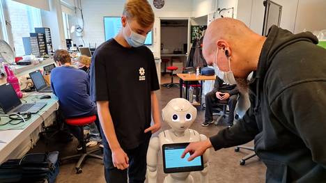 Palvelurobotti saa käskyjä hyvinvointiteknologia-alan opiskelijalta Lauri Purolalta ja opettaja Juho Vuopalalta Karkun Voimarinteellä. 