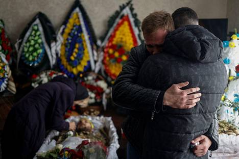 Ukrainalaisen sotilaan ystävät halasivat toisiaan tämän hautajaisissa Letytšivin kaupungissa 1. helmikuuta. Sotilaan on kerrottu kuolleen taistelussa Venäjän joukkoja vastaan Itä-Ukrainan Bahmutin alueella.