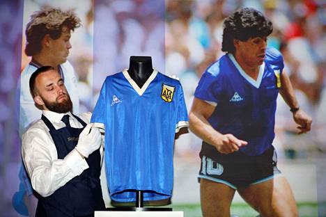 Huutokaupan työntekijä esitteli Diego Maradonan pelipaitaa. 
