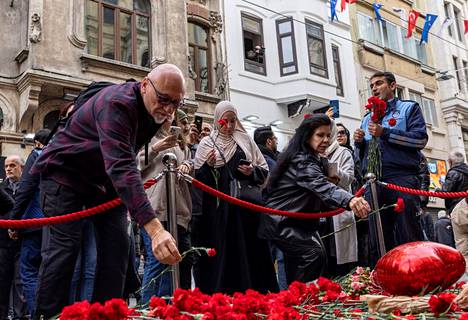 Ihmiset laskevat kukkia sunnuntaisen pommi-iskun uhrien muistoksi Istiklal-kadulla.