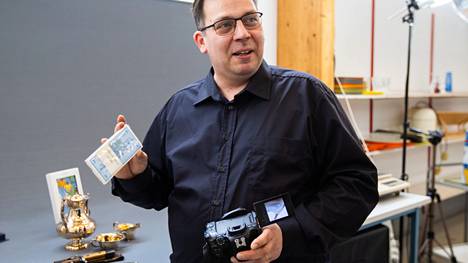 Antti Ruohola aloitti Nostalgiamarketin yrittäjänä maaliskuussa. Kädessään hänellä on pakka painosileitä viiden markan seteleitä. Toisessa kädessä on kamera, sillä Ruohola kuvaa paljon tuotteita näytille.