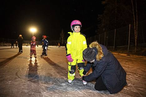 Annele Matintupa sitoo tyttärensä Nanna Matintuvan, 6, luistimia Lempäälän Lastusten kylässä.