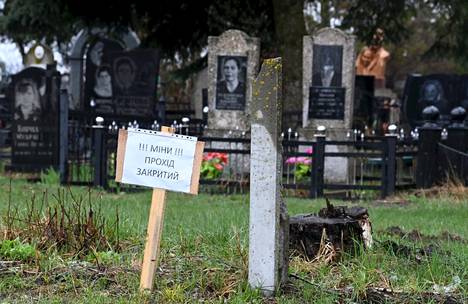 Miinoja, pääsy kielletty -kyltti Makarivin hautausmaalla Ukrainassa 20. huhtikuuta.