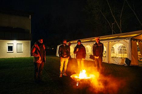 Scharjil Ahmad Khalid, Ebham Malhi, Rizwan Rasheed ja Riszwan Ahmad kokoontuivat tulen ääreen rukousten jälkeen moskeijan pihalla Berliinissä tiistaina.