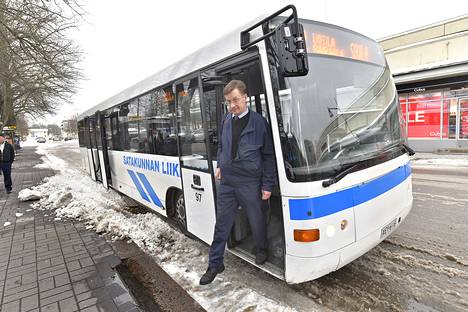 Jari Lännistö astuu ulos kuljettajavuorostaan Savilassa. Sielläkin lunta on kertynyt pieni kerros bussilaiturin reunaan.