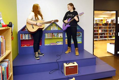 Kahdeksasluokkalaiset Enna Mäensivu ja Helli Päiviälä asettuivat testaamaan Pomarkun kirjastoon lainattavaksi hankittuja akustista ja sähkökitaraa.