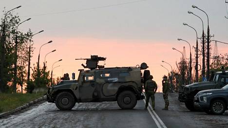 Venäjä-mielisiin joukkoihin kuuluvat sotilaat seisoivat vartioissa ennen kuin Azovstalista poistuvia ukrainalaissotilaita lähdettiin kuljettamaan pois alueelta torstaina 19. toukokuuta.