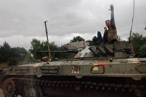 Ukrainalainen sotilas tervehti kuvaajaa panssarivaunun luukusta Harkovan alueella tiistaina.