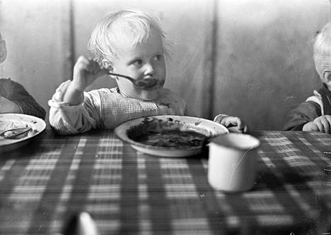 Arkistokuvassa porilaislapsi nauttii lounasta vuonna 1938.
