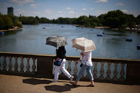 Lontoon Hyde Parkissa auringolta voi suojautua vaikkapa sateenvarjon avulla. Kuva otettu puiston Serpentine-järven läheisyydestä 9. heinäkuuta 2022. 