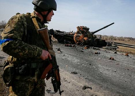 Ukrainalainen sotilas kuvattiin tuhotun venäläistankin edustalla 28. maaliskuuta.