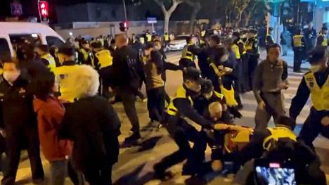Poliisi pidättää tiukkoja koronarajoituksia vastustavia mielenosoittajia Shanghaissa. Kuvakaappaus Reutersin haltuunsa saamalta videolta.
