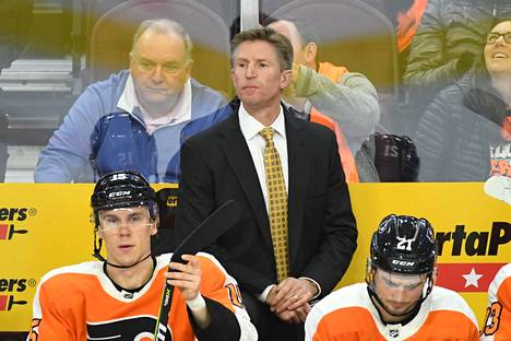 Philadelphia Flyersia valmentanut Dave Hakstol (keskellä) kuvattuna joulukuussa 2018. Penkilää istuu muuan Jori Lehterä (vas.).