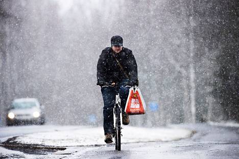 Lumisade yllätti pyöräilijän Tampereella 6. huhtikuuta 2021.