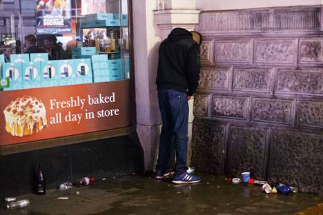 Uutta vuotta juhlinut mies helpotti oloaan seinää vasten Lontoon keskustassa vuonna 2016.