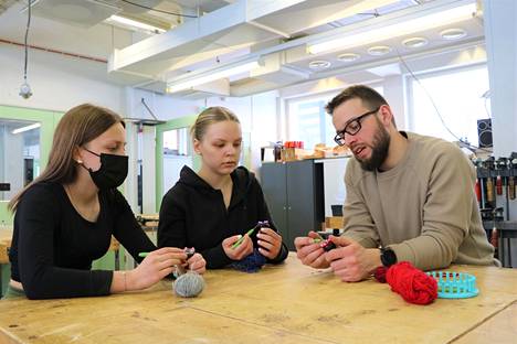 Olli Itäsalo (oik) näytti Enriikka Juutilaiselle ja Minea Koskelle, miten knitting dollya käytetään.