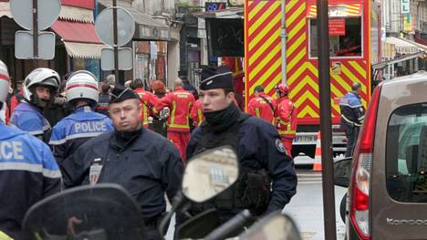 Pelastuslaitoksen työntekijät ja poliisit turvasivat perjantaina katua, jossa ammuskelu tapahtui Pariisissa.
