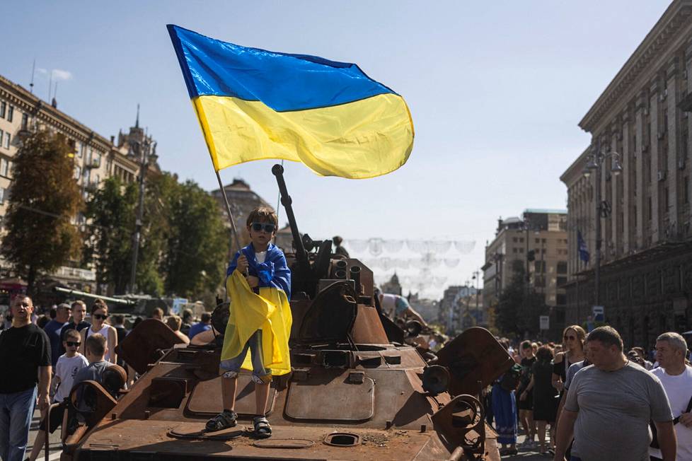 Poika heilutti Ukrainan lippua tuhotun venäläisen panssariajoneuvon päällä itsenäisyyspäivänä Kiovassa.