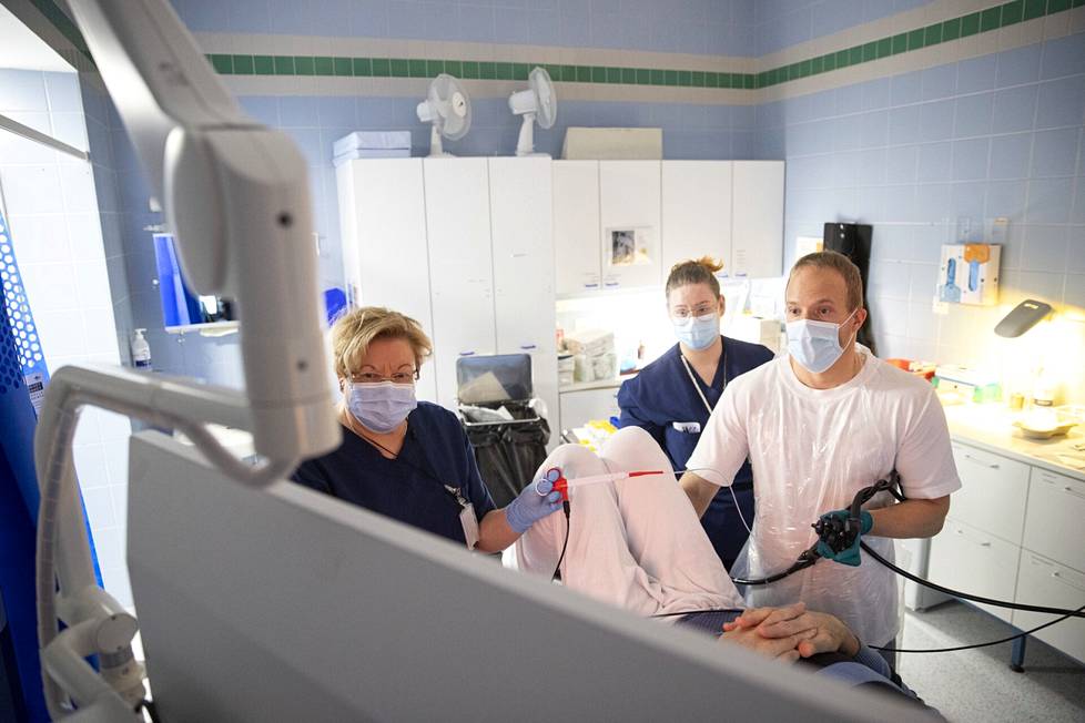 Satasairaalan ylilääkäri, gastroenterologi Juha Liikala tekee potilaalle paksusuolen tähystystä. Toimenpidettä avustavat sairaanhoitajat Tiina Honkasalo (vasemmalla) ja Karoliina Porola.