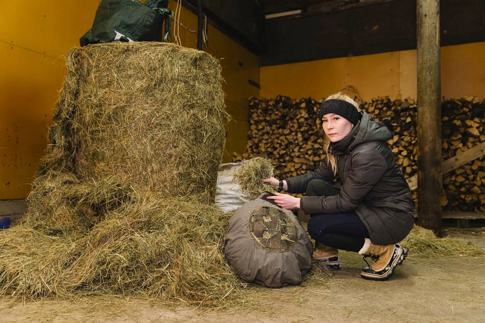 Anna-Sofia Keränen täyttää heinätyynyä. Siitä syöminen on hevoselle hitaampaa, ja se auttaa painonhallinnassa.