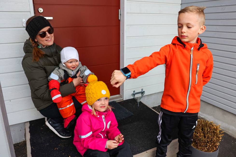 7-vuotias Eero Lukkonen (oik.) esittelee kellopuhelintaan. Pienemmät sisarukset Sara, 4, ja Aapo, 1, voivat saada isoveljen kellon aikanaan käyttöön. Äiti Riina Ahonen pitää kellopuhelinta älypuhelinta turvallisempana vaihtoehtona.
