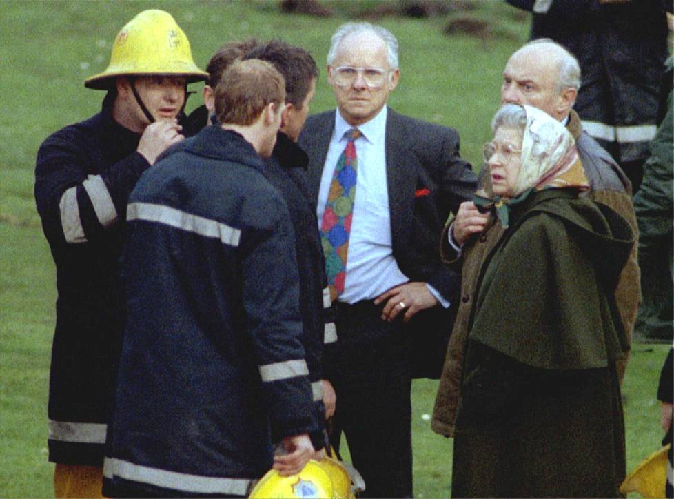Pelastushenkilökuntaa ja kuningatar Elisabet Windsorin linnan edessä tulipalon jälkeen.